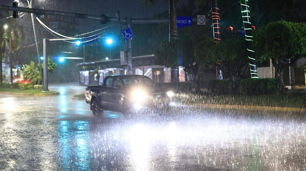Un auto circula bajo la lluvia este miércoles 18 de junio de 2025, en el balneario de Acapulco en Guerrero México. 