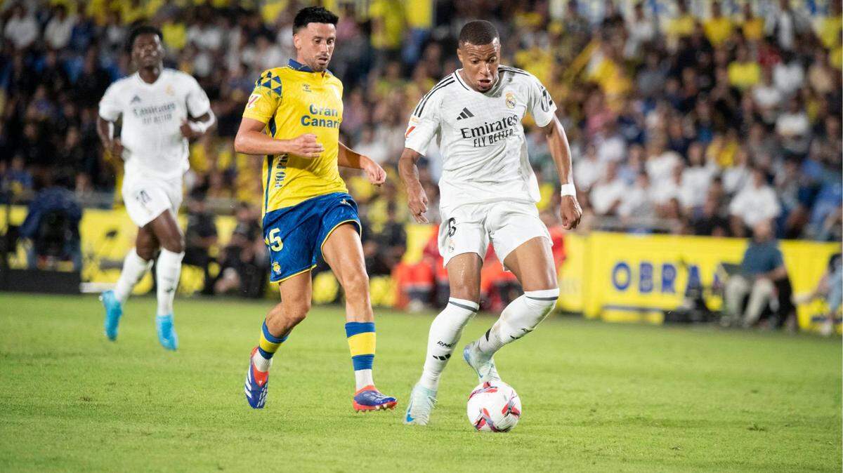 El delantero del Real Madrid Kylian Mbappé (der.) conduce la pelota en el partido ante Las Palmas, celebrado el 29 de agosto de 2024 en Gran Canaria, España.