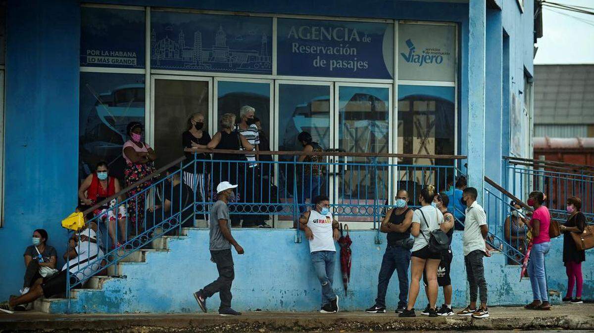 Cubanos hacen cola en una agencia de reserva de boletos de La Habana, el 1 de noviembre de 2021. - Los habaneros vuelven a llenar las calles anticipando el declive del covid-19, luego de la pesadilla de julio y agosto cuando se registraron casos pico en la isla. , que se espera que abra sus fronteras el 15 de noviembre.  YAMIL LAGE / AFP-Getty Images