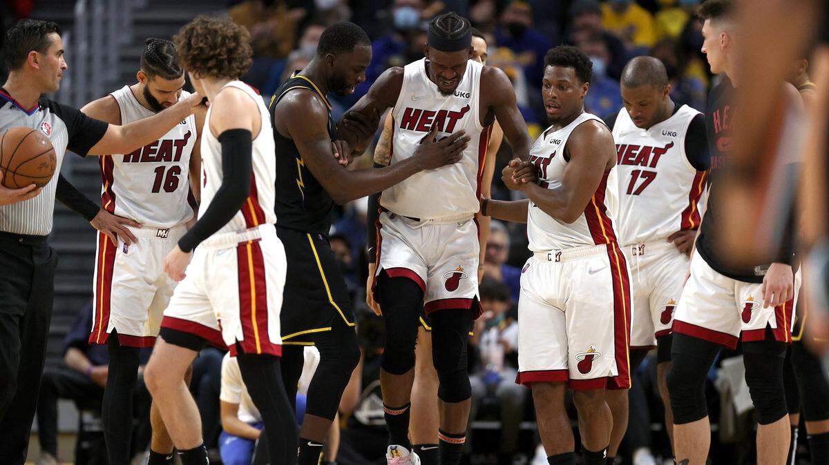 El jugador del Heat de Miami Jimmy Butler es ayudado por Kyle Lowry (der.) y Draymond Green, en el tercer cuarto del partido ante los Warriors de Golden State, celebrado el 3 de enero de 2022 en San Francisco.