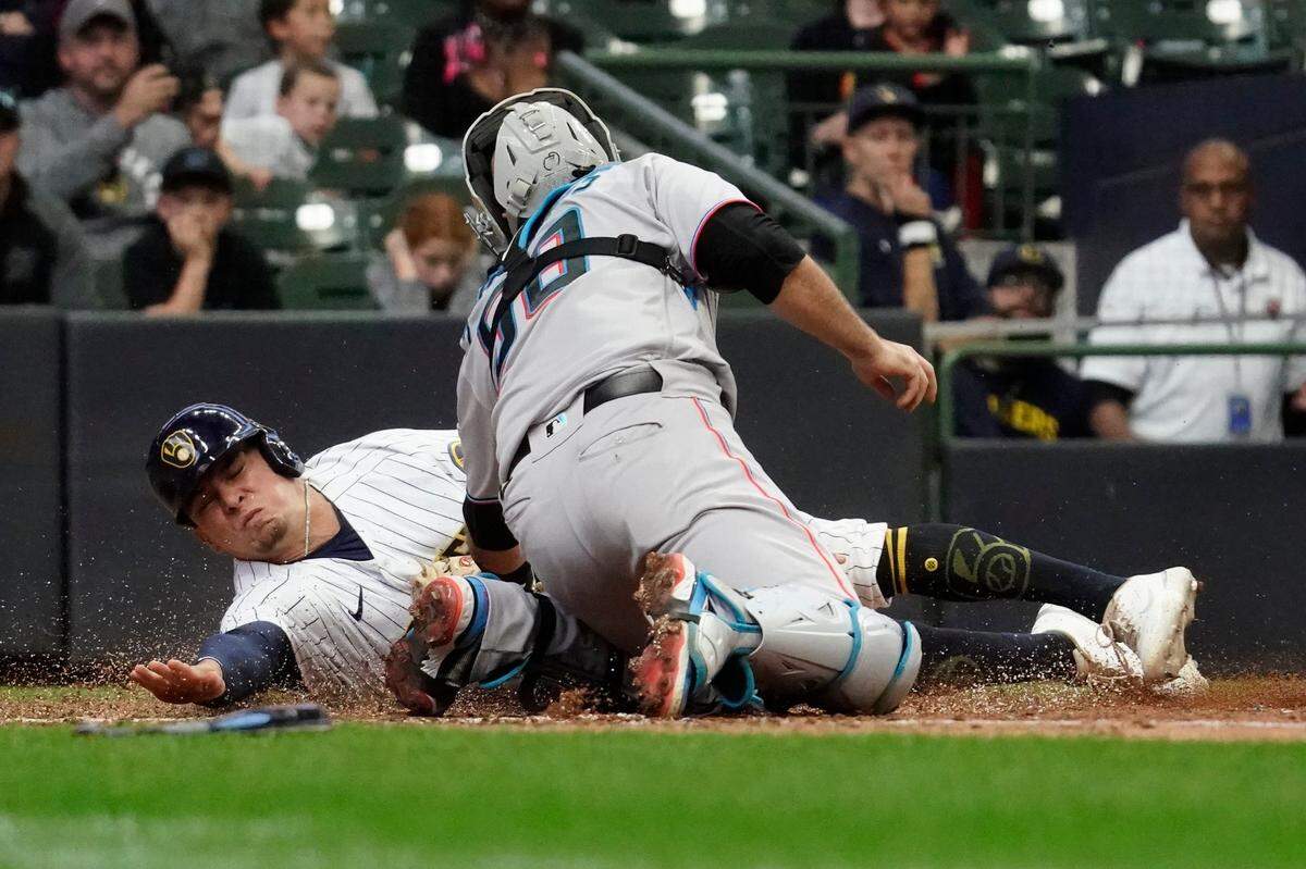 El tercera base de los Cerveceros Luis Urías es puesto out en home por el receptor de los Marlins de Miami Jacob Stallings, en el partido celebrado el el domingo 2 de octubre de 2022 en Milwaukee.