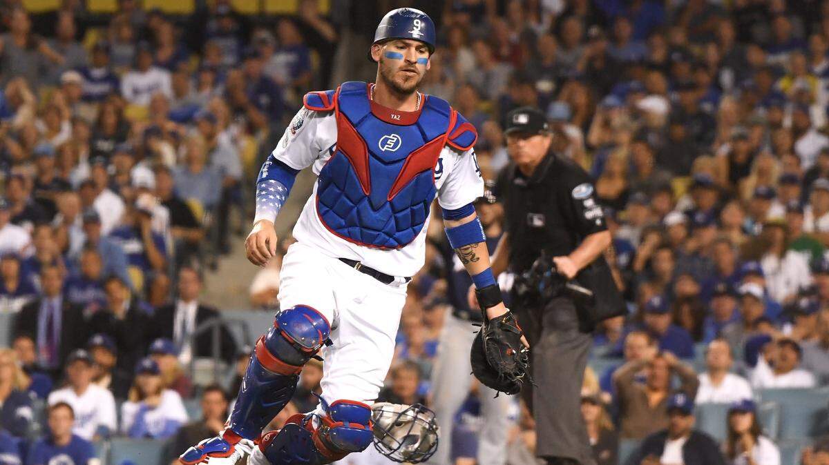 El receptor de los Dodgers Yasmani Grandal busca una pelota lanzada sin control por el pitcher Travis Shaw, en el tercer juego de la Serie de Campeonato ante los Cerveceros, el 15 de octubre de 2018 en Los Angeles.