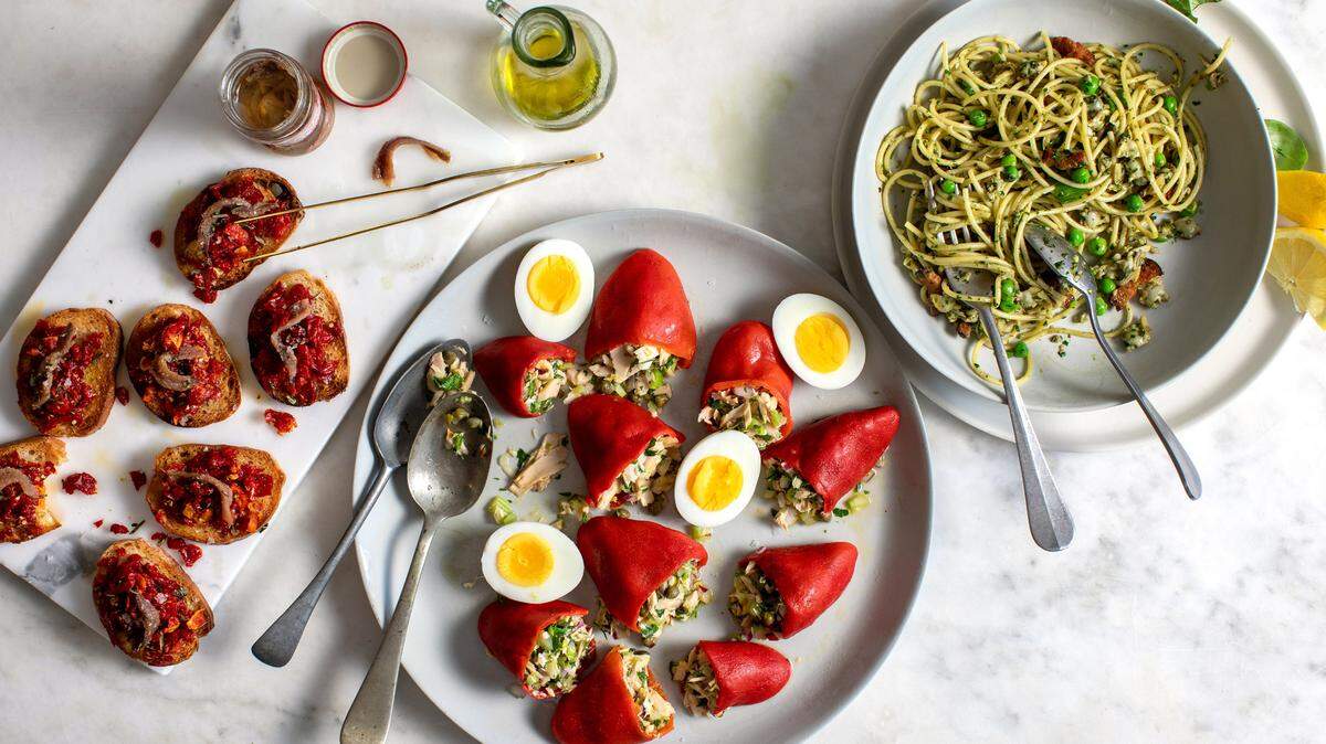 De izquierda a derecha, crostini con tomates secados al sol y anchoas, piquillos rellenos de atún y pasta picante de almejas con tocino, chícharos y albahaca.