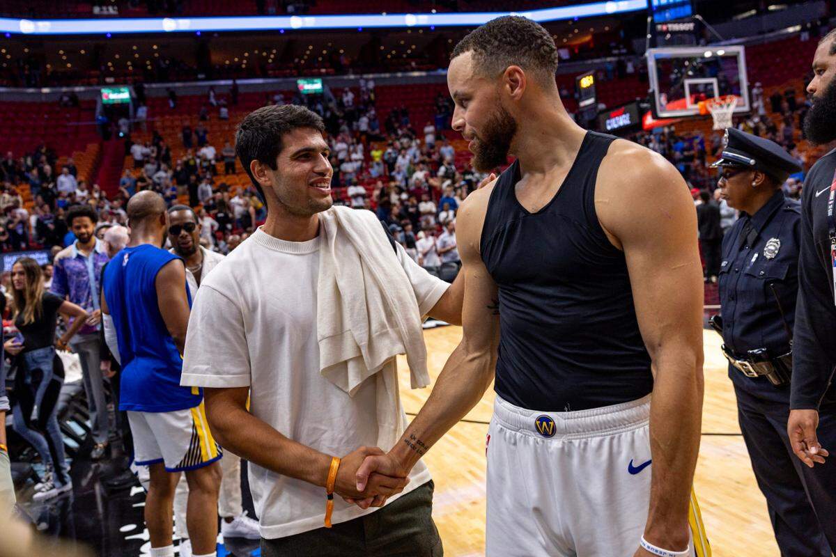 El jugador de los Warriors de Golden State Stephen Curry (der.) saluda al tenista español Carlos Alcaraz al finalizar el partido contra el Heat, celebrado el 26 de marzo de 2024 en Miami.