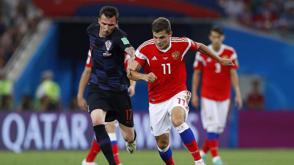 El centrocampista ruso Román Zobnin (der.) es el futbolista que más kilómetros ha hecho de media en lo que va de Copa Mundial con 12,4 kilómetros por partido.