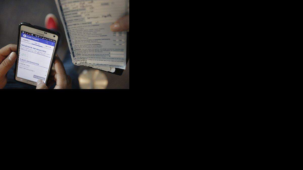 José Ciprian, un residente de Tampa, escribe su información personal y declaración de aduanas en la aplicación Pasaporte Móvil (Mobile Passport). El uso de avances tecnológicos ha ayudado a reducir el tiempo de espera en las filas de inmigración en el Aeropuerto Internacional de Miami.  