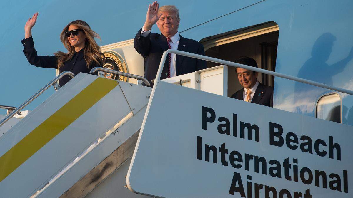 El presidente de Estados Unidos, Donald Trump, la primera dama, Melania Trump, y el primer ministro japonés, Shinzo Abe, descienden del Air Force One en el Aeropuerto Internacional de Palm Beach, en Florida, a su llegada para pasar el fin de semana en el complejo turístico Mar-a-Lago de Trump, el 10 de febrero de 2017.