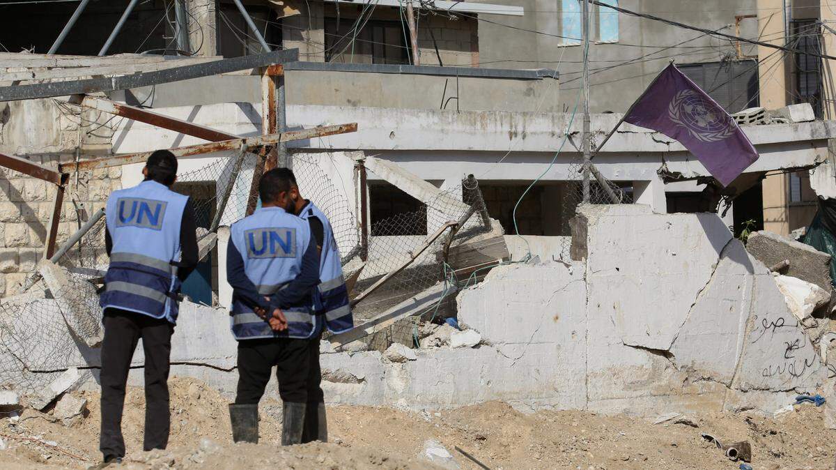 Dos personas con chalecos de la ONU observan la demolición de una oficina de la Agencia de la ONU para los Refugiados Palestinos (Unrwa), que fue destruida por un bombardeo israelí, en el campamento Nur Shams en el norte de Cisjordania, el viernes 1 de noviembre de 2024.