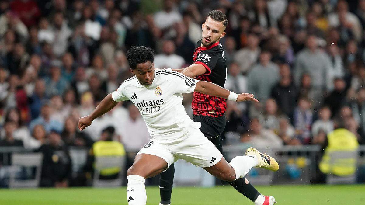 El jugador del Real Madrid Endrick Felipe (izq.) conduce el balón ante la marca de José Copete, del Mallorca, en el partido de la liga española celebrado el 14 de mayo de 2025 en Madrid.