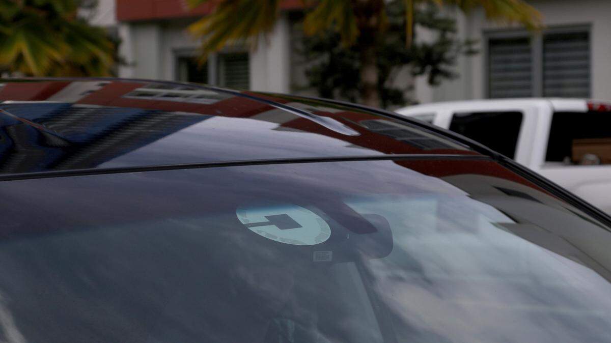 FILE- In this June 6, 2018, file photo Uber driver Joshua Oh drives in Honolulu. Uber has created a feature on its app to reach out to passengers and drivers if it detects an accident or unplanned stop. Drivers will also have access to a hands-free feature to pick up passengers without touching their phones, and they will no longer see data detailing where they retrieved passengers in the past. (AP Photo/Caleb Jones, File)