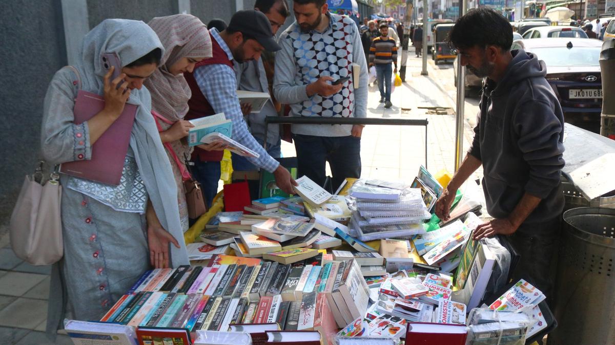 Varias personas eligen libros para comprarlos a un vendedor ambulante en el Día Mundial del Libro en Srinagar, Cachemira, India, el 23 de abril de 2024.