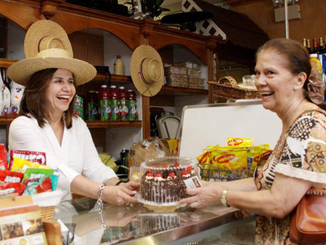 Pamela Canales entrega una torta de selva negra chilena a una de sus clientas.