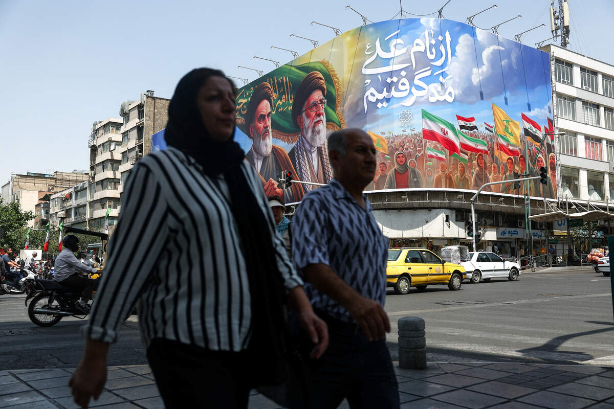 Un grupo de personas pasa junto a una valla publicitaria que representa al difunto líder de la Revolución Islámica, el ayatolá Ruhollah Jomeini, y al difunto líder supremo de Irán, el ayatolá Ali Jamenei, en una calle de Teherán, Irán, el 6 de junio de 2026. Majid Asgaripour/WANA (Agencia de Noticias de Asia Occidental) vía REUTERS