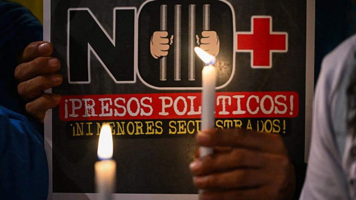 A Venezuelan citizen holds a candle during a vigil against Venezuela's President Nicolas Maduro and in support of US President Donald Trump at Lourdes Park in Bogota on December 3, 2025. Venezuela's President Nicolas Maduro confirmed on December 3, 2025, that he had a "cordial" phone call with his US counterpart Donald Trump 10 days ago amid a US military buildup in Latin America. (Photo by Luis ACOSTA / AFP via Getty Images)