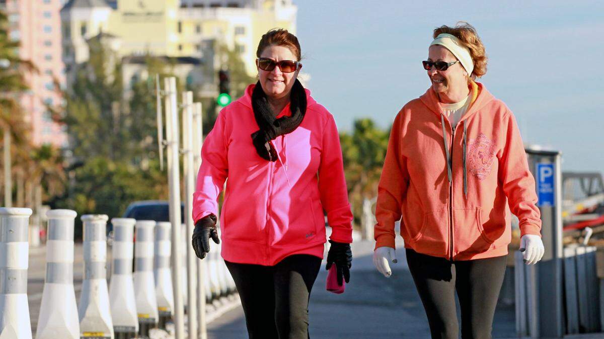 In this 2014 file photo, Jennie DiRosa and Jenny Boese walk along Fort Lauderdale beach on a chilly January morning. Forecasters predict temperatures in the low 50s for Jan. 5, 2020, with wind chills in the 40s.