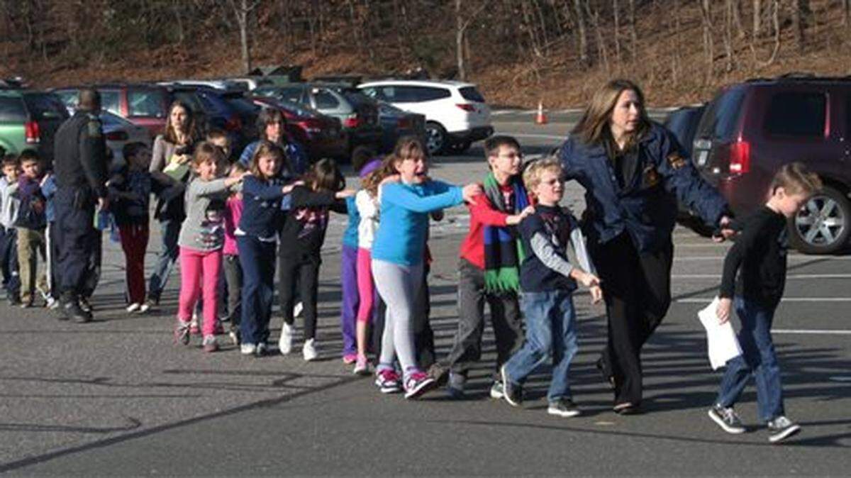 La policía estatal de Connecticut ayuda a unos niños en fila de la escuela Sandy Hook Elementary School en Newtown. El 14 de diciembre de 2012 Adam Lamza, mata a 26 personas, entre ellas 20 niños, en una escuela primaria de Newtown en Connecticut antes de suicidarse. El día anterior había matado a su madre en su casa.
