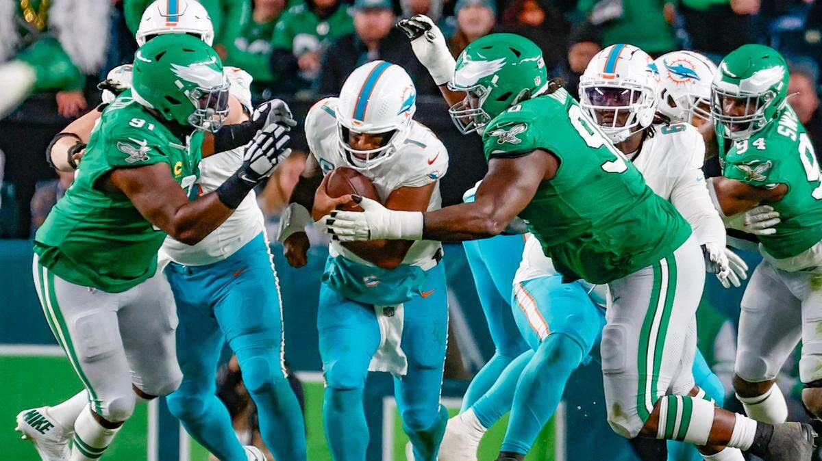 El quarterback de los Dolphins Tua Tagovailoa es detenido por el defensive tackle de los Eagles Fletcher Cox (izq.) y el defensive tackle Jordan Davis, en el último cuarto del partido celebrado el 22 de octubre de 2023 en Filadelfia.