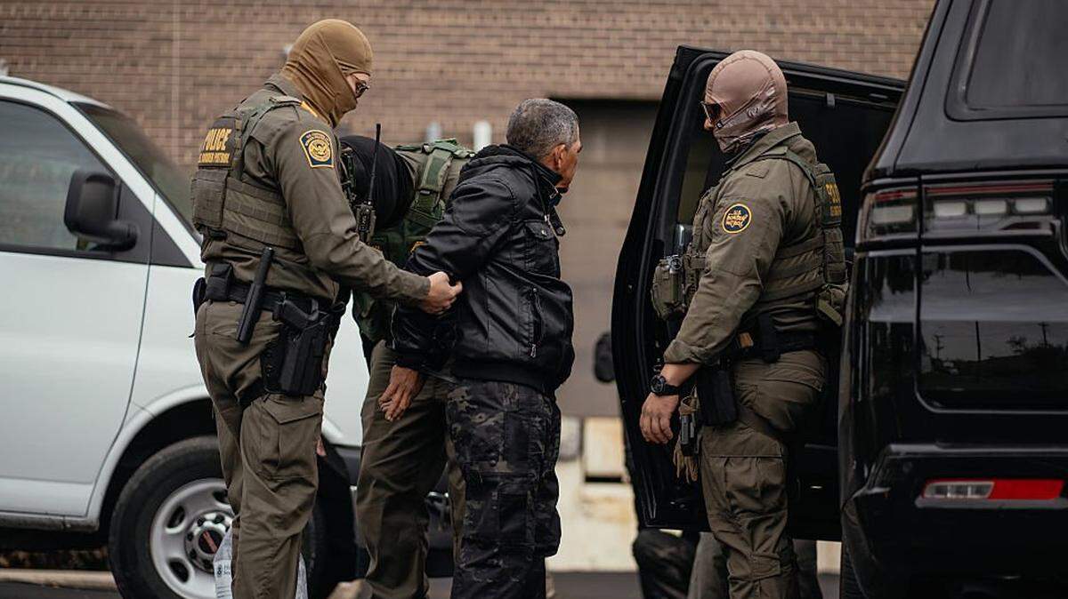 Varias personas detenidas a lo largo del día son trasladadas a un estacionamiento en el extremo norte de la ciudad antes de ser transferidas a un centro del Servicio de Inmigración y Control de Aduanas (ICE) el 31 de octubre de 2025, en Chicago, Illinois.