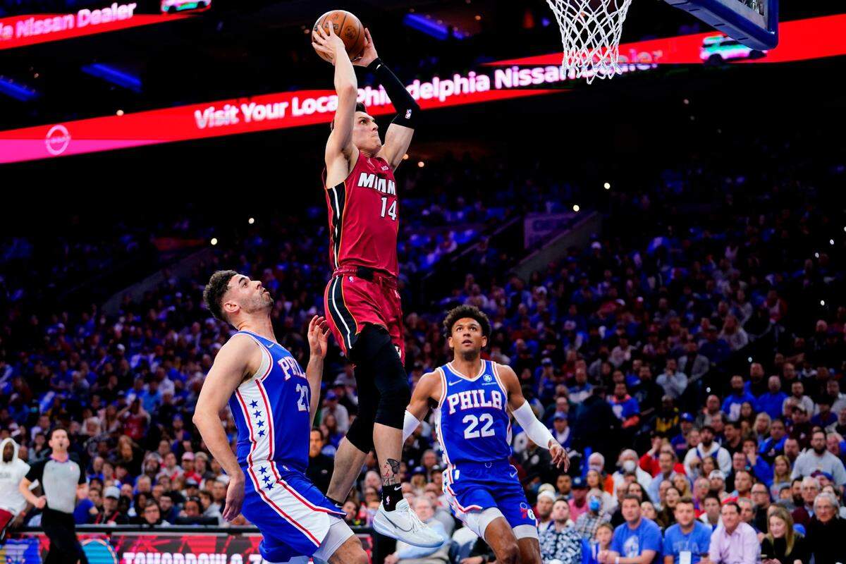 El jugador del Heat Tyler Herro entra al aro ante la marca de Georges Niang (izq.) y Matisse Thybulle, de los 76ers, en el partido celebrado el 6 de mayo de 2022 en Filadelfia.