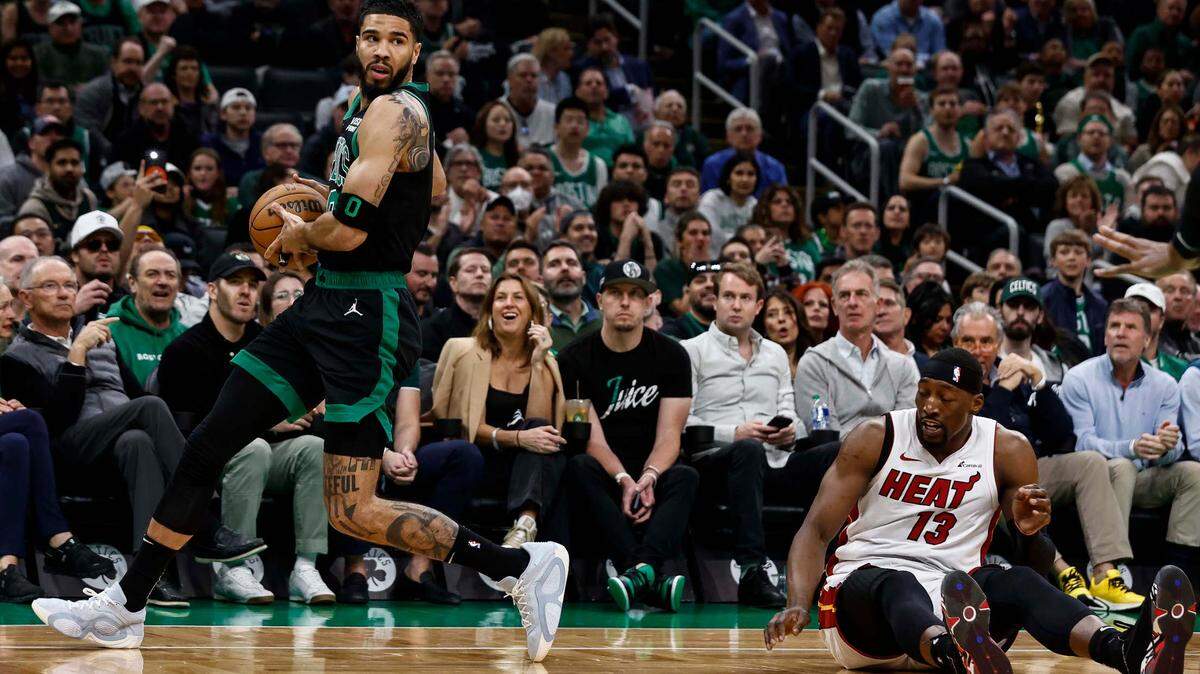 El delantero de los Boston Celtics, Jayson Tatum (0), agarra un balón suelto junto al caído centro del Miami Heat, Bam Adebayo (13), durante el primer cuarto del quinto juego de la primera ronda de los playoffs de la NBA de 2024 este 1 de mayo de 2024 en el TD Garden, en Boston, Massachusetts.