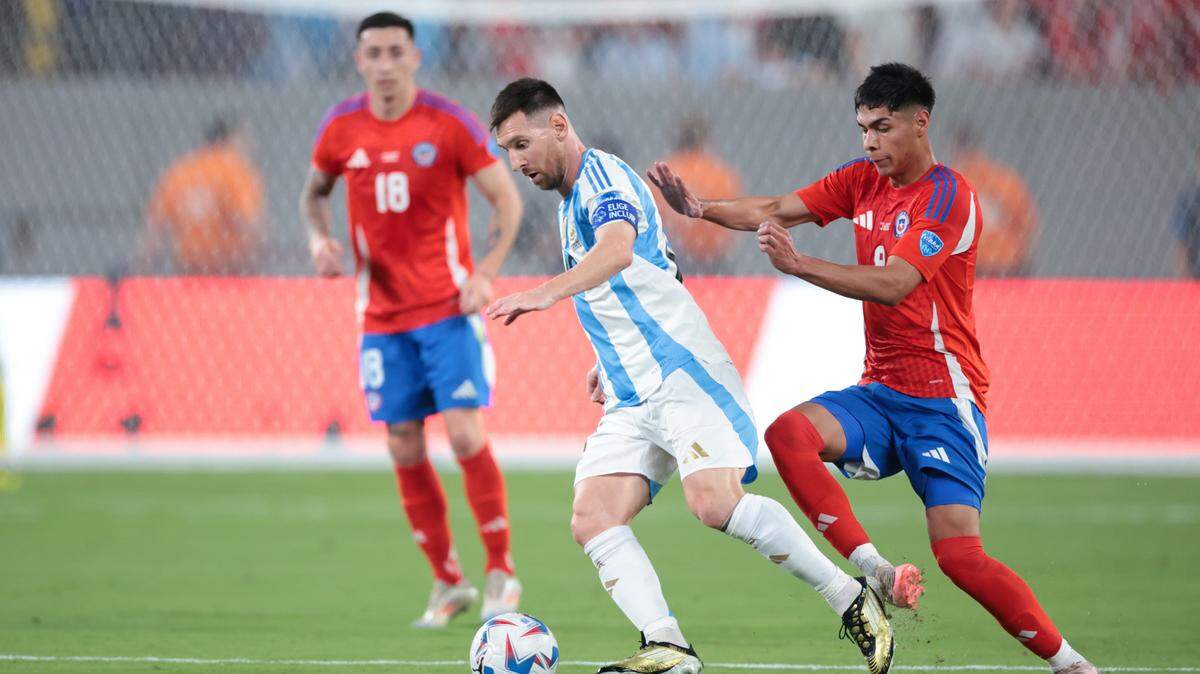 El astro de Argentina Lionel Messi (centro) trata de burlar la marca de Víctor Dávila, de Chile, en el partido de la Copa América celebrado el 25 de junio de 2024 en el MetLife Stadium en Nueva Jersey.