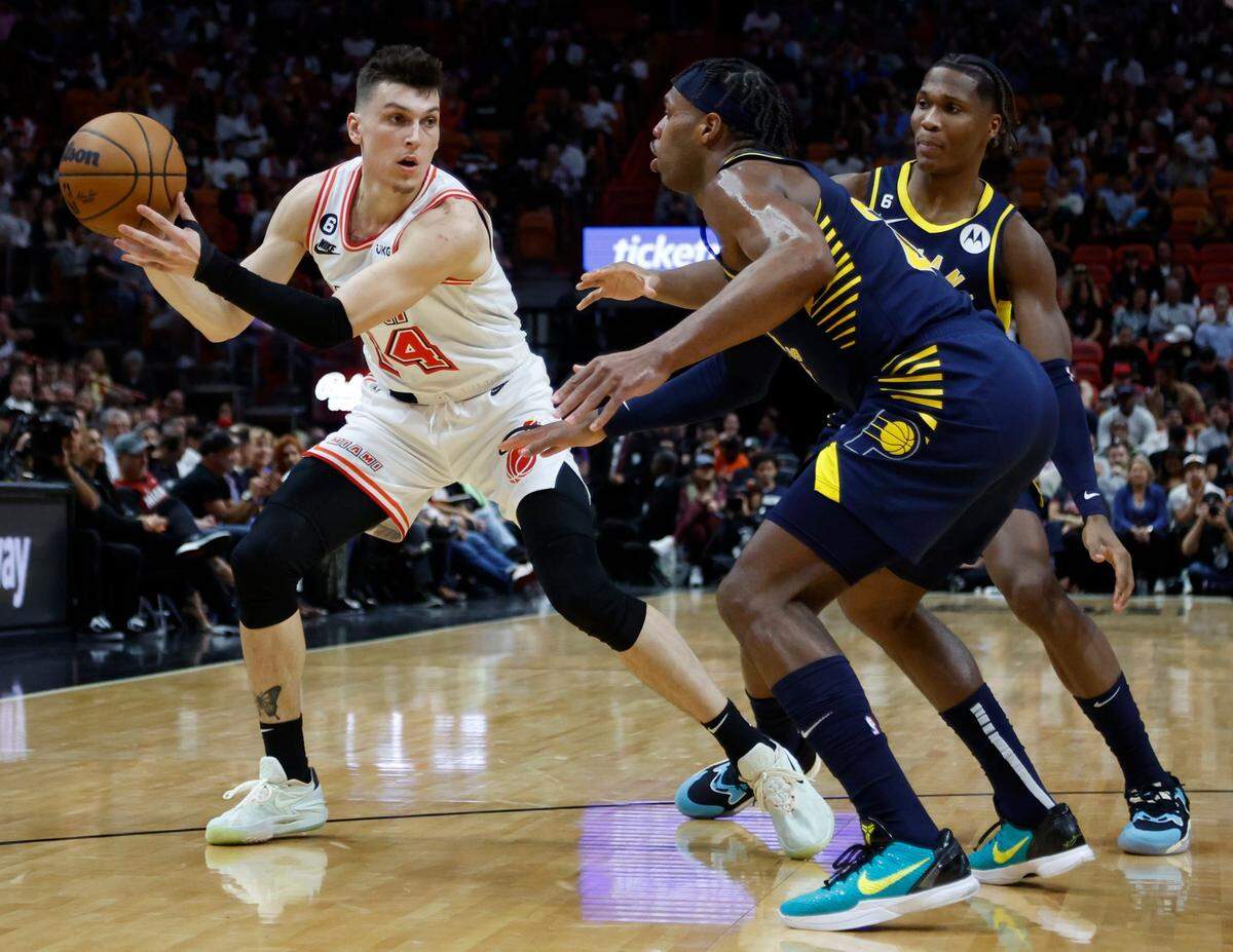 El jugador del Heat Tyler Herro (14) controla la pelota ante la marca de Bennedict Mathurin (centro) y Buddy Hield, de los Pacers de Indiana, en el partido celebrado el 8 de febrero de 2023 en Miami.