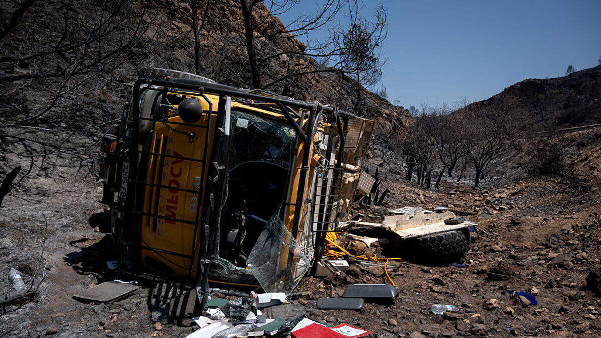 Un vehículo accidentado del servicio de extinción de incendios INFOCA de Andalucía yace volcado en un paisaje calcinado, días después de un incendio forestal en Bédar, cerca de Almería, España, el lunes 13 de julio de 2026.