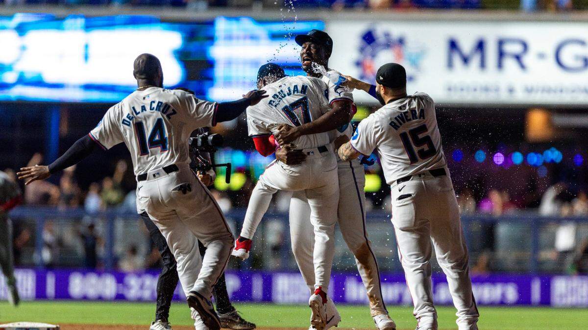 El bateador emergenrte de los Marlins Vidal Bruján (17) es felicitado tras pegar el hit que dejó al campo a los Cardenales de San Luis en el décimo inning, en el partido celebrado el 18 de junio de 2024 en Miami.