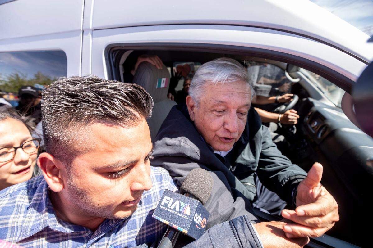 El presidente mexicano, Andrés Manuel López Obrador, habla con un activista migrante que exige justicia para los 38 migrantes muertos cuando sale del Colegio de Bachilleres en Ciudad Juárez durante su visita el 31 de marzo de 2023.