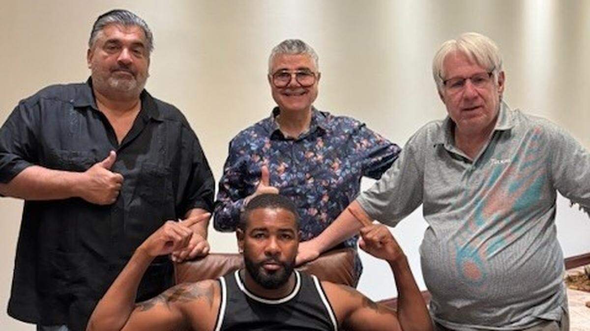 Yuniel Dorticós tras firmar su nuevo pacto promocional con Kris Lawrence, de The Heavyweight Factory (izq.), y los ejecutivos de Warriors Luis de Cubas Sr. (centro) y León Margules.