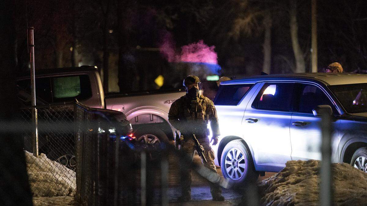 Agentes federales resguardan un perímetro tras un incidente de disparos mientras residentes enfadados protestan su presencia en la ciudad el 14 de enero de 2026 en Mineápolis, Minnesota.