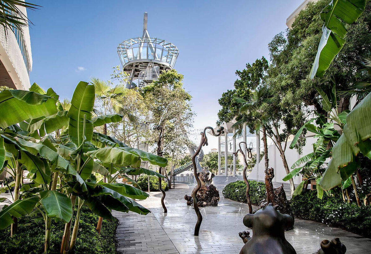 Un corredor al aire libre en Aventura Mall conduce al tobogán de vidrio y acero de 93 pies de Carsten Höller. Aventura Mall