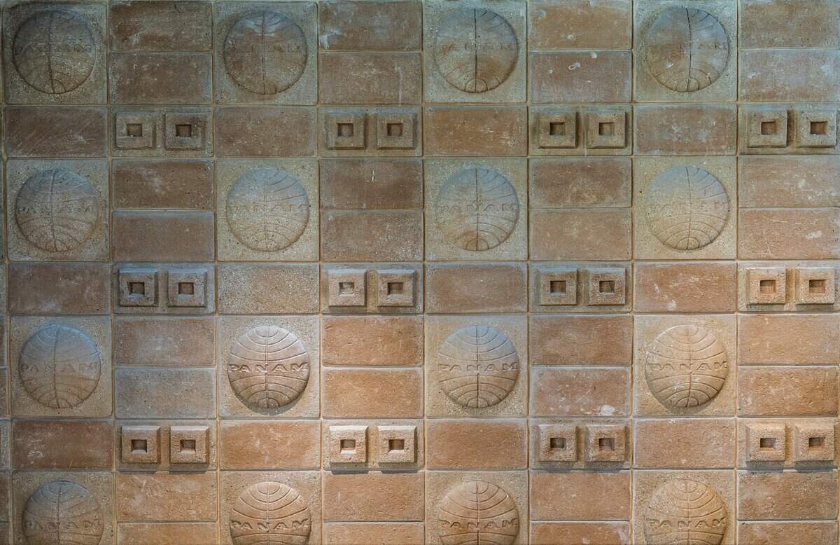 Detalle del logotipo original de Pan Am en una pared de azulejos de PS MIA, una terminal privada de lujo en el Aeropuerto Internacional de Miami que permite a los pasajeros de vuelos comerciales evitar las multitudes de la terminal principal del aeropuerto. Ubicada en la histórica antigua sede de Pan American Airways (4900 NW 36th St), ofrece controles privados de la TSA, trámites de Aduanas, comidas preparadas por chefs, servicios de spa y traslados a la pista en un BMW, el viernes 12 de junio de 2026.