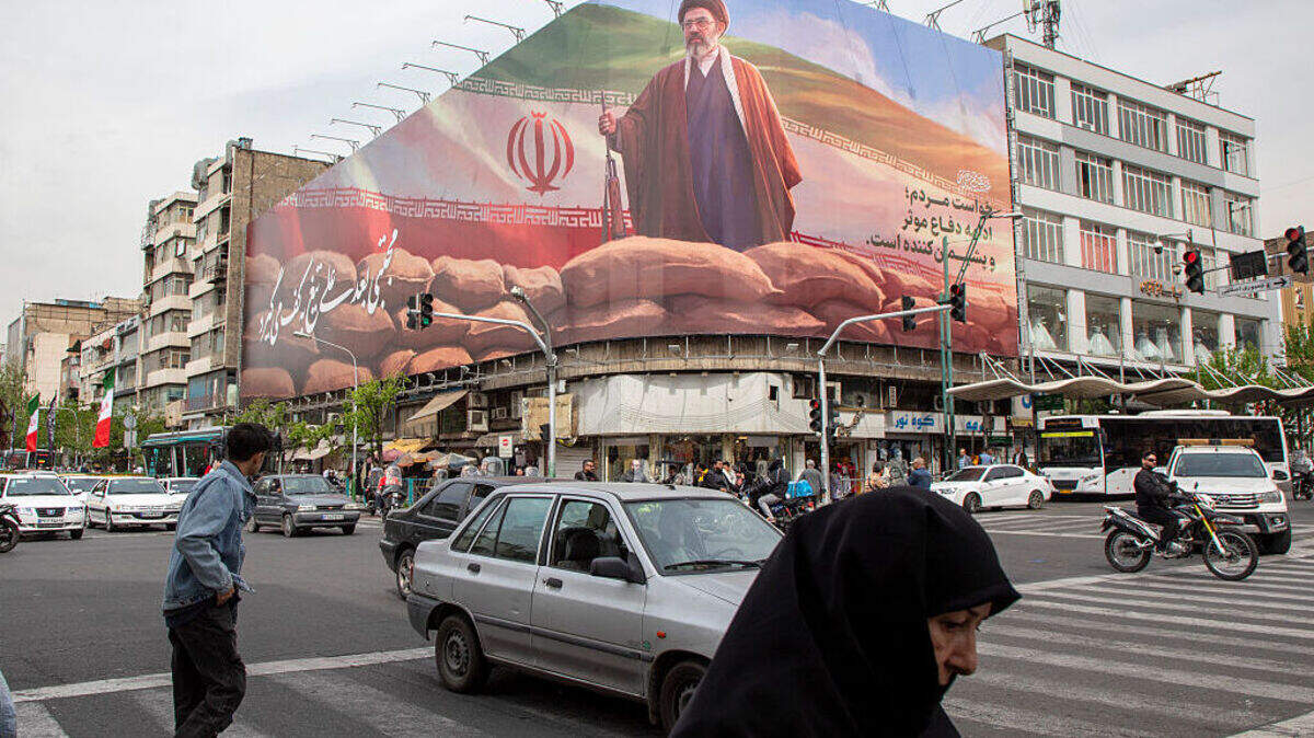Peatones y automovilistas pasan bajo una pancarta que muestra un retrato de Mojtaba Khamenei, el nuevo Líder Supremo de Irán, el domingo 12 de abril de 2026 en Teherán, Irán.