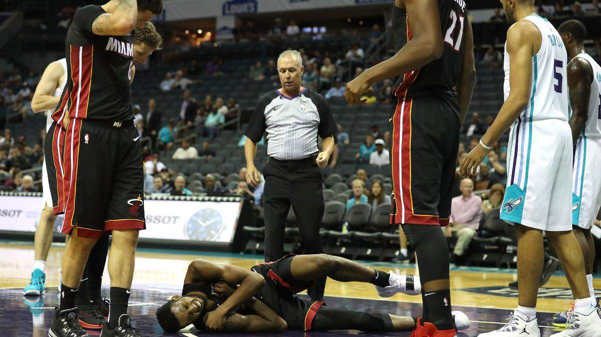 El jugador del Heat  Derrick Jones Jr. se golpeó el hombro tras sufrir una fuerte caída en el segundo cuarto del juego ante los Hornets, el 2 de octubre de 2018 en Charlotte.