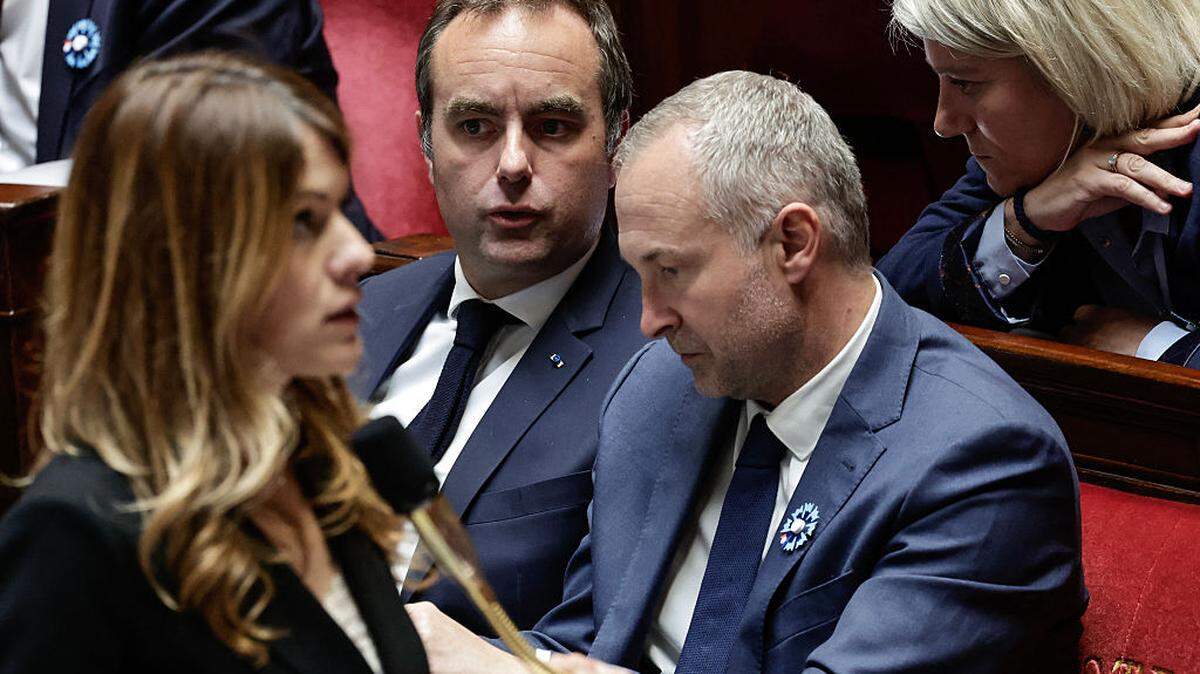 El primer ministro de Francia, Sébastien Lecornu (c), conversa con el ministro delegado de Francia encargado de las relaciones con el Parlamento, Laurent Panifous (2.º a la d.), y con la ministra de Salud de Francia, Stéphanie Rist (d.), mientras la portavoz del Gobierno francés, Maud Bregeon (i.), interviene durante una sesión de preguntas al Gobierno en la Asamblea Nacional.