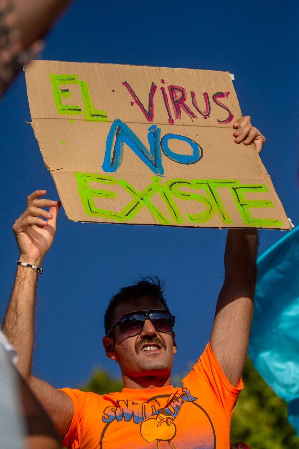 A demonstrator attends a protest against nationwide restrictions against COVID-19 in Madrid, Spain, Sunday, Aug. 16, 2020. Banner reads in Spanish “The Virus doesn’t exist”. (AP Photo/Andrea Comas)