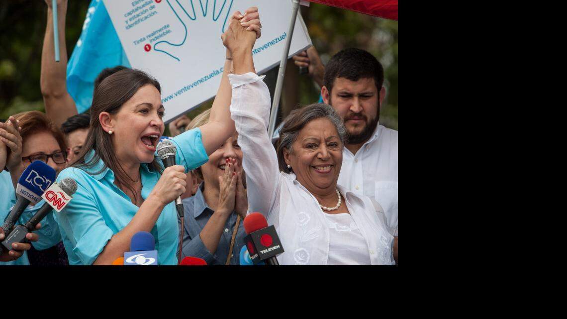 La ex diputada venezolana de la Asamblea Nacional (AN) María Corina Machado (izq.), junto a la candidata Isabel Pereira, asiste a la sede de la Junta Electoral Principal para inscribir su candidatura para las elecciones parlamentarias de diciembre del presente año, el lunes 3 de agosto de 2015, en la ciudad de Los Teques, Venezuela.
