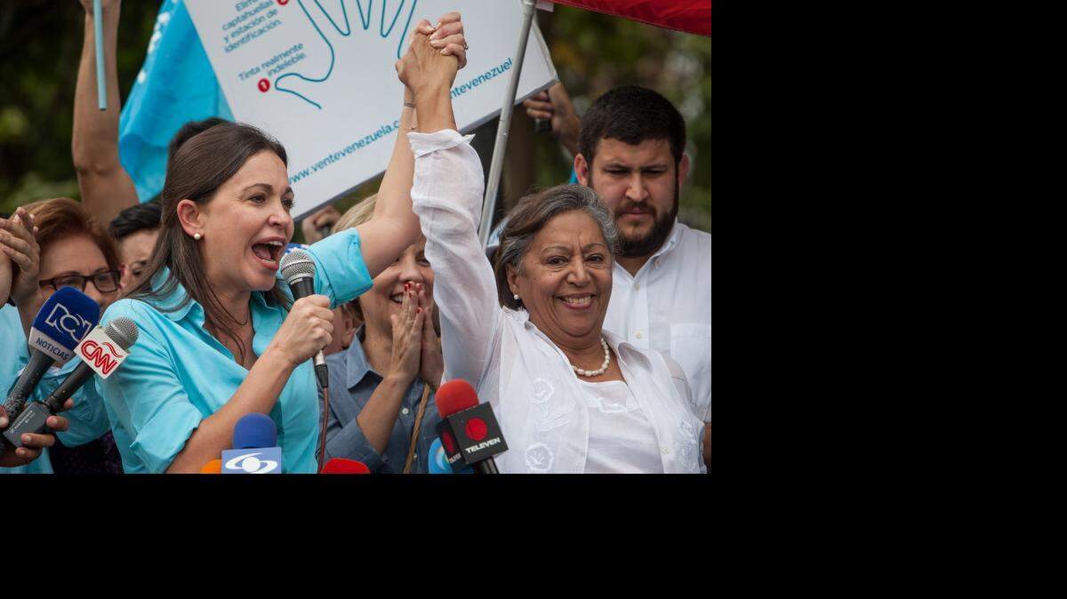 La ex diputada venezolana de la Asamblea Nacional (AN) María Corina Machado (izq.), junto a la candidata Isabel Pereira, asiste a la sede de la Junta Electoral Principal para inscribir su candidatura para las elecciones parlamentarias de diciembre del presente año, el lunes 3 de agosto de 2015, en la ciudad de Los Teques, Venezuela.