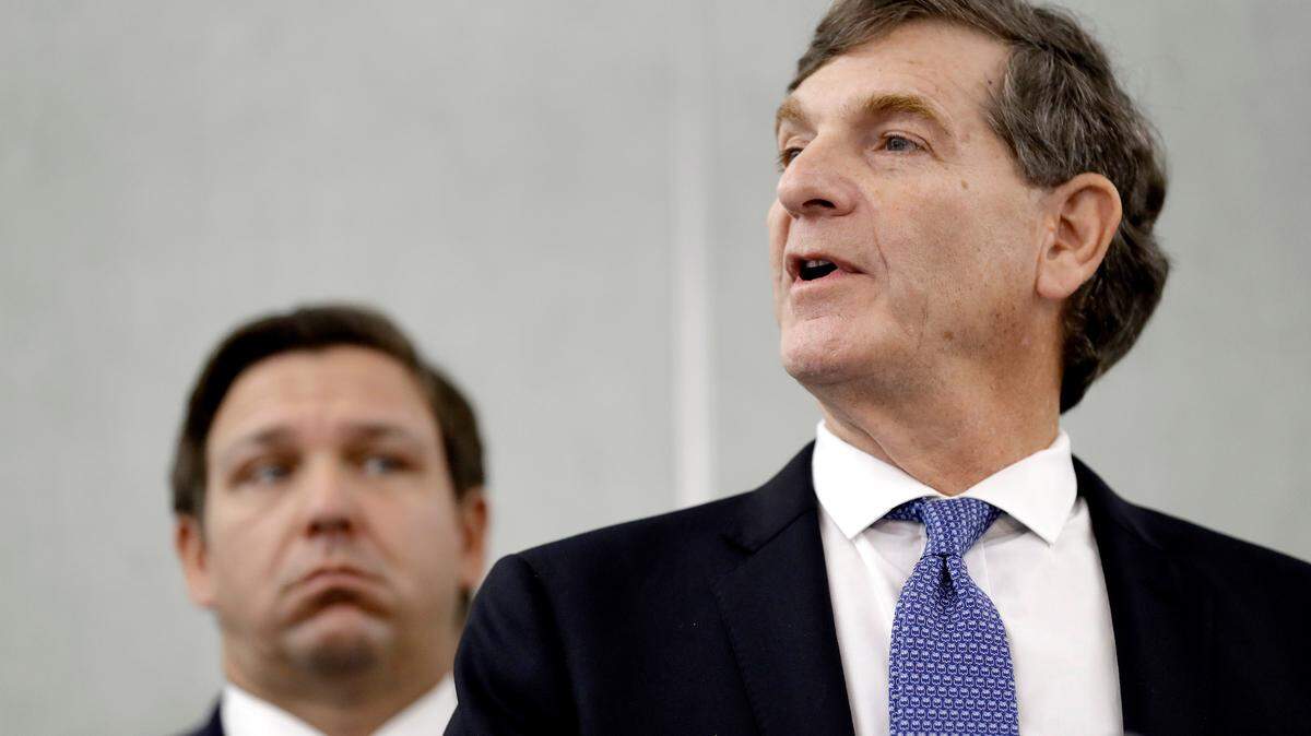 FILE- Florida Surgeon General Dr. Scott Rivkees, right, speaks to the media as Florida Gov. Ron DeSantis looks on during a news conference Monday, March 2, 2020, in Tampa, Fla. Rivkees has accepted a job at Brown University, Monday, Nov. 22, 2021,  to work on the school’s pandemic preparedness. (AP Photo/Chris O’Meara, File)