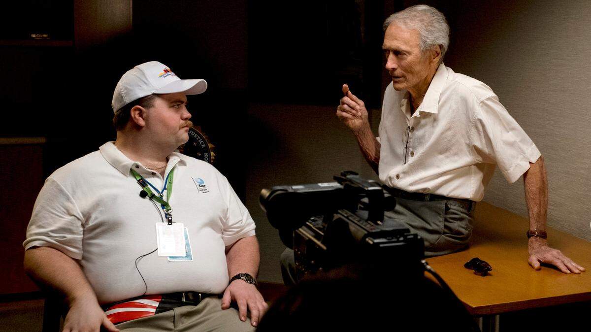 El director Clint Eastwood (der.) conversa con el actor Paul Walter durante la filmación de la película “Richard Jewell”, en una imagen distribuida por Warner Bros. Pictures.