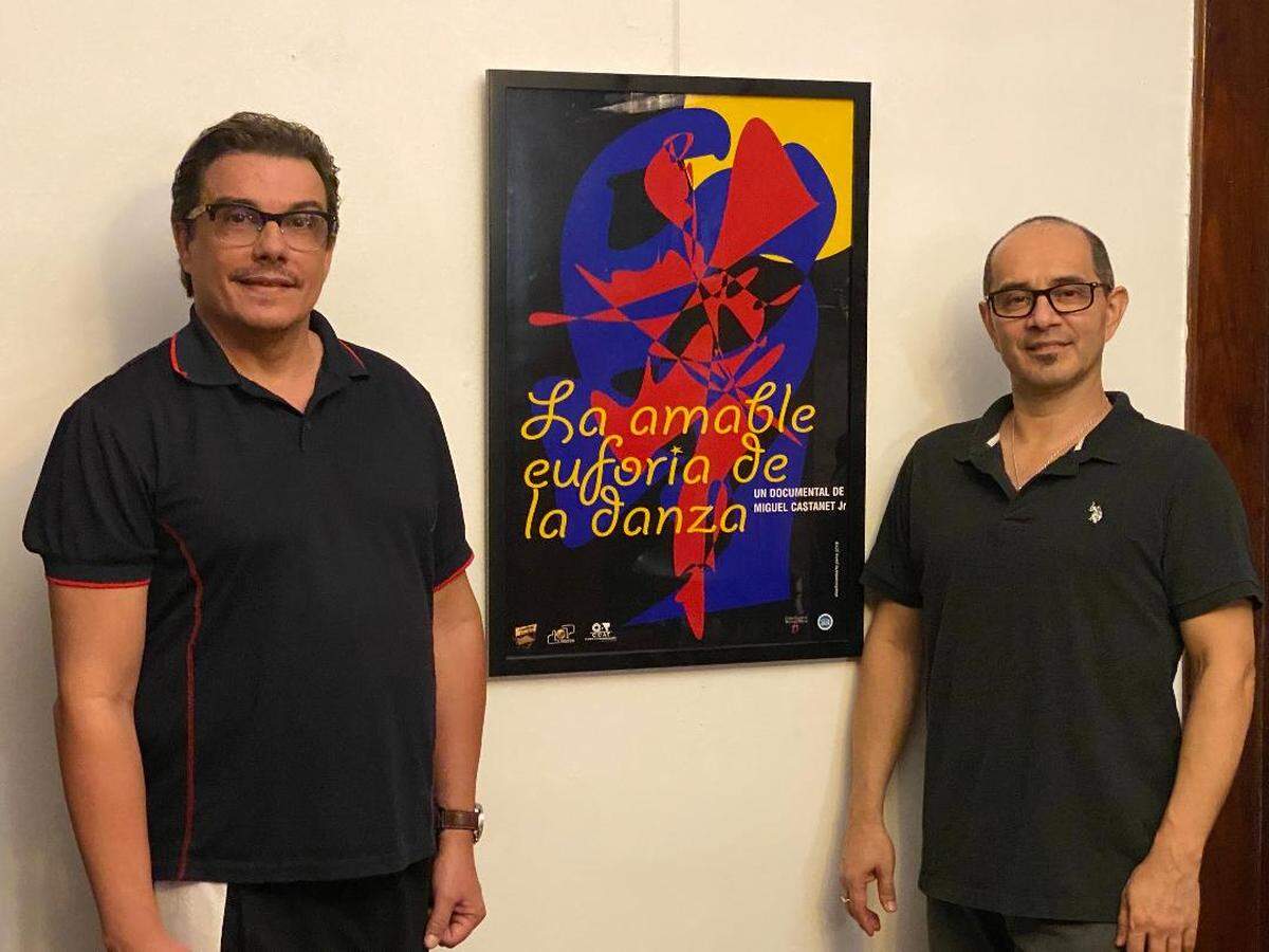 Miguel Castañet Jr y Eriberto Jiménez junto al póster de “La amable euforia de la danza”.