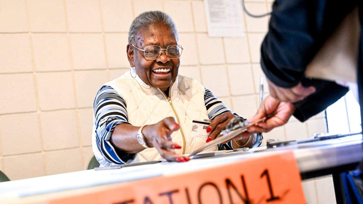 La trabajadora electoral Mary Jackson ayuda a un votante de las primarias en el nuevo colegio electoral de Potter Park Zoo, el martes 27 de febrero de 2024 en Lansing, Michigan.