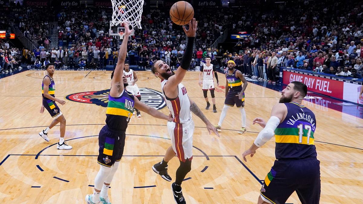 El delantero del Heat de Miami Caleb Martin (16) entra al aro ante la marca de CJ McCollum (izq.) y Jonas Valanciunas, de los Pelicans, en el partido celebrado el 18 de enero de 2023 en New Orleans.