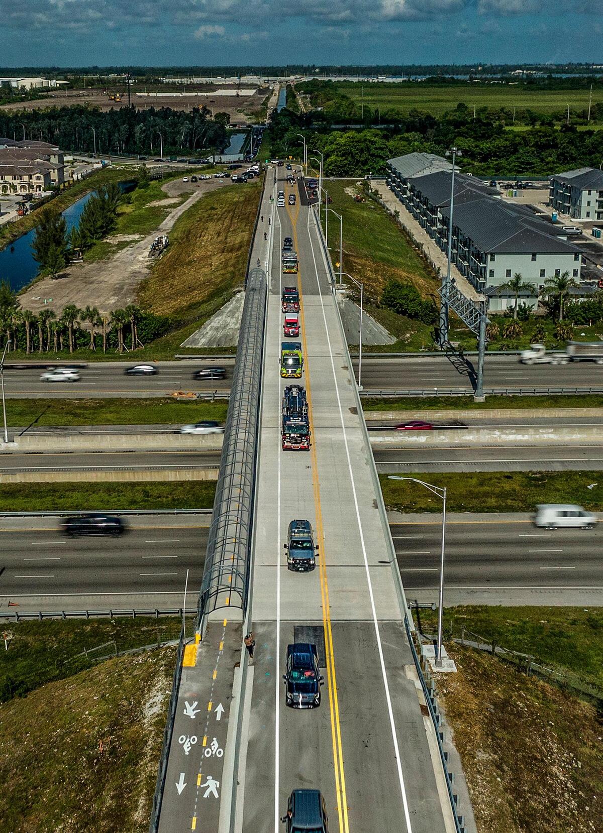 Una caravana que incluye vehículos de emergencia y fuerzas del orden cruza el puente de NW 170th St que cruza la interestatal 75 y conecta Hialeah y Miami Lakes después de una ceremonia de apertura presidida por el alcalde de Hialeah, Esteban Bovo, Jr. El puente fue finalmente inaugurado luego de años de conflictos entre la Ciudad de Hialeah y Miami Lakes que se oponían a la apertura, el martes 16 de agosto de 2022.