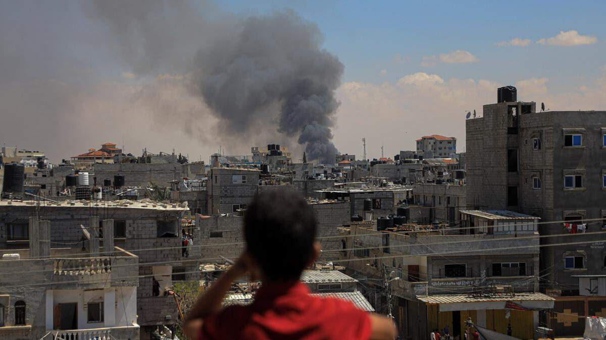 Un niño mira una columna de humo causada por un bombardeo israelí en la ciudad de Rafah, en el sur de Gaza, el martes 7 de mayo de 2024.