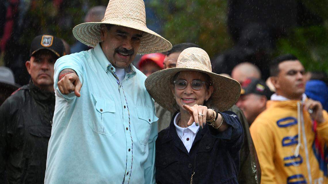 Venezuela's President Nicolas Maduro gestures next to his wife, First Lady Cilia Flores, during a rally to mark the anniversary of the Battle of Santa Ines, in Caracas on December 10, 2025. (Photo by Federico PARRA / AFP via Getty Images)
