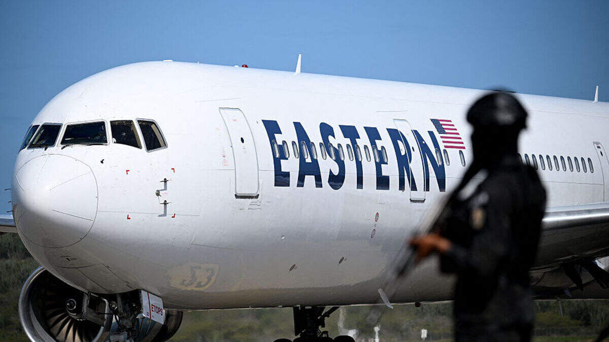 Foto de archivo del 16 de enero de 2026, que muestra a un agente de la Policía Nacional Bolivariana cerca de un avión de Eastern Airlines, que aterrizó con migrantes venezolanos repatriados de Estados Unidos, en el Aeropuerto Internacional Simón Bolívar de Maiquetía, Caracas.