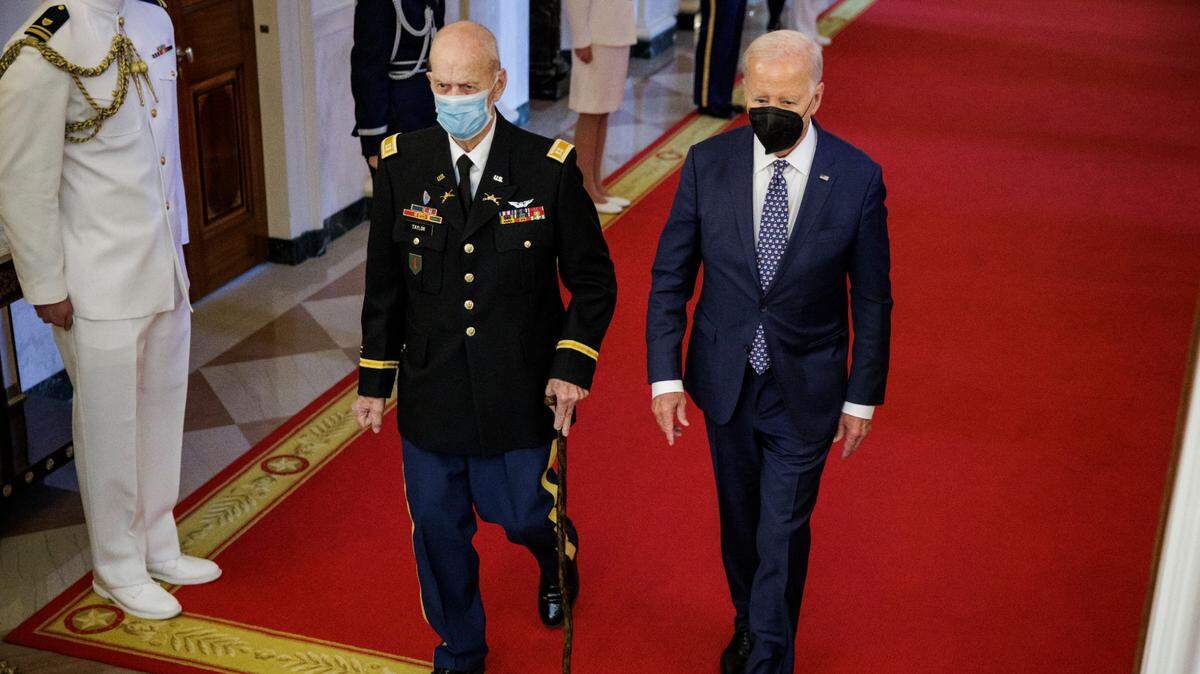El presidente Joe Biden y el capitán del ejército estadounidense Larry Taylor llegan a la ceremonia donde se le rindió honor al piloto de la Guerra de Vietnam de 81 años. 