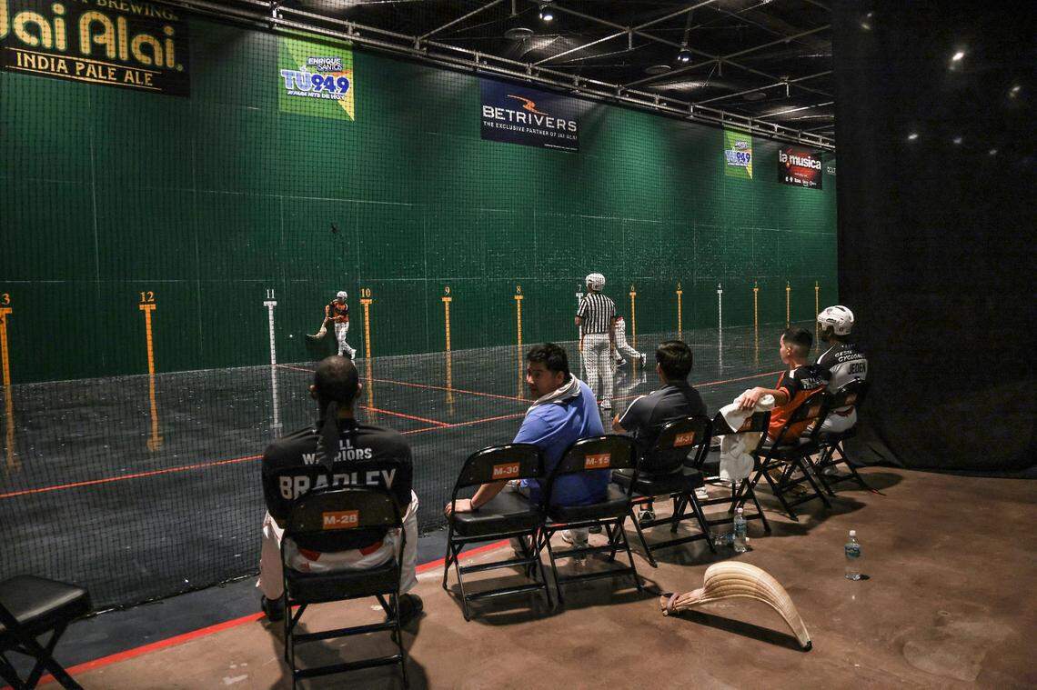 Miembros de un equipo de jai-alai observan a sus compañeros competir durante un partido el 6 de marzo de 2022 en el Magic City Casino en Miami, Florida.